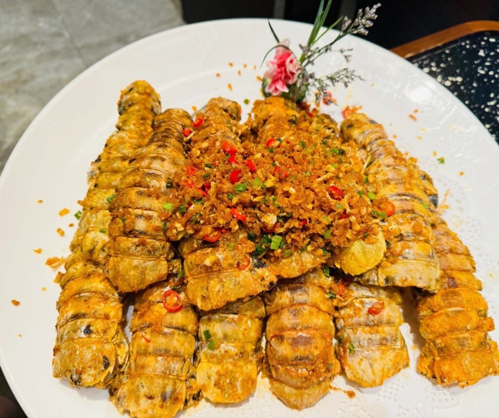 Salt and Pepper Mantis Shrimp is a classic Cantonese seafood dish, very popular in Hong Kong and Guangdong. Mantis shrimp, also known as shrimp cracker, is a nutritious seafood. The salt and pepper method originated from a simple way of cooking seafood. After deep-frying at high temperature, it is seasoned with salt and pepper, which can maintain the freshness of the seafood and increase the spicy taste. The popularity of this dish also reflects Cantonese cuisine's emphasis on seafood ingredients and innovation in flavor. Features： The characteristic of Salt and Pepper Mantis Shrimp is its crispy on the outside and tender on the inside texture and spicy, salty and umami taste. After being deep-fried, the mantis shrimp has a crispy shell and tender shrimp meat. The aroma of salt and pepper and the stimulation of chili make this dish full of flavor and very appetizing. Ingredients： Mantis shrimp: 500g Dry starch: 50g Garlic: 30g Dried chili: 10g Sichuan peppercorns: 5g Scallions: 15g Ginger: 10g Cooking wine: 15ml Salt: appropriate amount White pepper powder: appropriate amount Cooking oil: appropriate amount Instructions： Process mantis shrimp: Wash the mantis shrimp, cut off the shrimp whiskers and shrimp feet, marinate with cooking wine, salt and white pepper powder for 15 minutes. Coat with starch: Coat the marinated mantis shrimp evenly with a layer of dry starch. Fry: Pour enough cooking oil into the pot, heat to 60% heat, put in the mantis shrimp and fry until golden brown and crispy, remove and drain the oil. Stir-fry salt and pepper: Leave a little oil in the pot, add minced garlic, dried chili segments, Sichuan peppercorns, minced ginger, and chopped green onions and stir-fry until fragrant, add appropriate amount of salt and white pepper powder to make salt and pepper. Mix: Put the fried mantis shrimp into the pot, stir-fry evenly with salt and pepper, and then serve. Precautions： Choose fresh mantis shrimp with plump meat. Control the oil temperature when frying to avoid burning. The saltiness of the salt and pepper should be adjusted according to personal taste. During the frying process, the mantis shrimp should be thoroughly fried to ensure that the inside is cooked through. If you like a richer taste, you can add some fried peanuts or cashews.